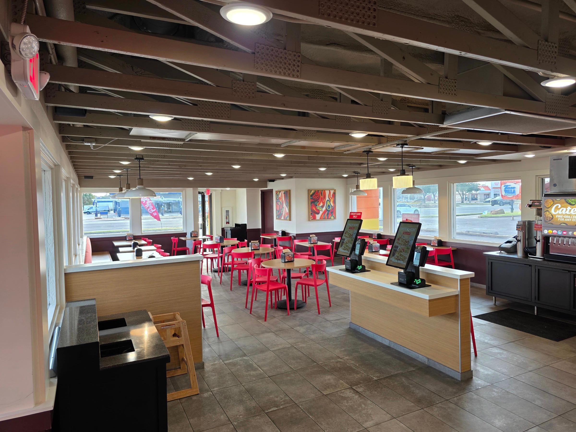 Restaurant dining interior buildout with exposed wood truss ceiling in Lubbock